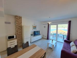 a living room with a couch and a table at Apartments Šišević - Comfort Apartments with Balconies and Sea View in Slano