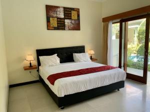 sypialnia z dużym łóżkiem i oknem w obiekcie Davit Guesthouse Nusa Dua w mieście Nusa Dua
