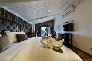 ein Schlafzimmer mit einem großen weißen Bett mit Kissen in der Unterkunft HOTEL METROPOLIS SRINAGAR in Srinagar