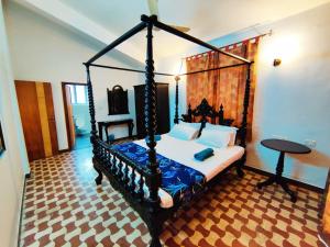 a bedroom with a canopy bed in a room at Luxury 3-BHK Villa with infinity Pool in Old Goa