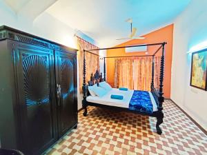 a bedroom with a canopy bed with blue sheets at Luxury 3-BHK Villa with infinity Pool in Old Goa