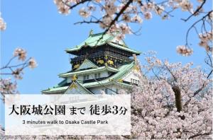 a tall building withakuraakura trees in front of it at LUXCARE HOTEL in Osaka