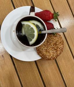 a cup of tea with lemon and strawberries on a plate at Green Training Center in Dzoraghpʼyur +16 photos