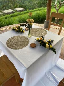 a white table with a vase of flowers on it at ECOZY by Biji Valley in Selat