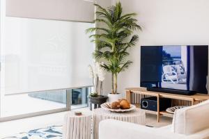 sala de estar con TV y mesa en Oceanview Retreat en Nelson