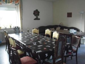 a dining room with a table and a table and chairs at Pension Ackermann in Mayen