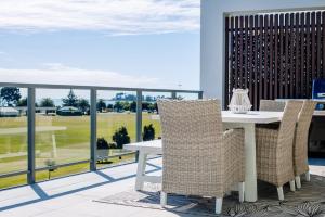 una mesa y sillas en un balcón con vistas en Oceanview Retreat en Nelson