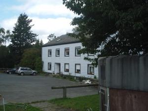 a white house with a car parked in front of it at Pension Ackermann in Mayen