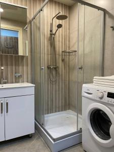 een douche in een badkamer met een wasmachine bij Coast Batumi Apart Hotel in Batoemi
