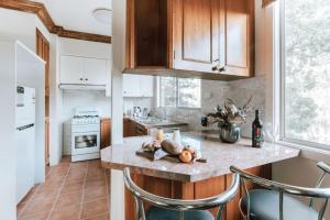 a kitchen with wooden cabinets and a counter with chairs at Olinda Nature Sunset Apartment in Olinda