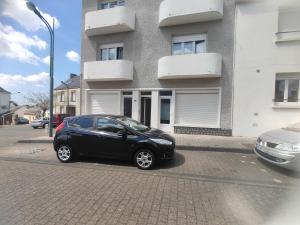 a black car parked in front of a building at Studio, TopdestinationBretagne in Montoir-de-Bretagne