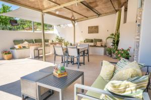 a patio with a couch and tables and chairs at Minas Apartments in Divarata