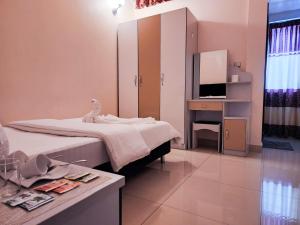 1 dormitorio con cama y escritorio con espejo en Reef Guest House en Male