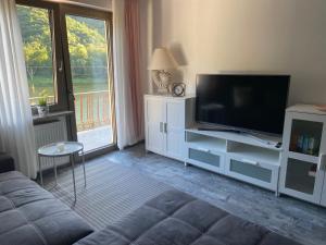 a living room with a couch and a flat screen tv at Haus Elsternest in Klotten