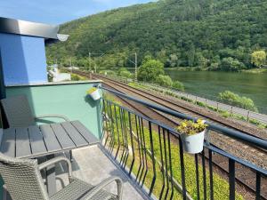 a balcony with a table and chairs next to a train track at Haus Elsternest in Klotten