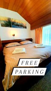 a bed with two towels on it with the words free parking at Pri Ancki B&B Ljubljana suburbs in Medvode