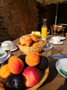 une table avec deux paniers de fruits et de pain dans l'établissement La Secrète, à Vogüé
