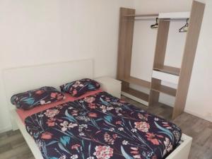 une chambre avec un lit avec une couette fleurie dans l'établissement T3 idéalement situé a Toulon, à Toulon