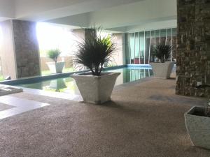 a lobby with potted plants and a swimming pool at Homestay SA De' Viana Apartment in Kota Bharu