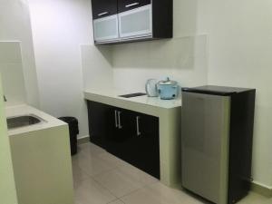 a small kitchen with a sink and a refrigerator at Homestay SA De' Viana Apartment in Kota Bharu