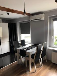 una sala da pranzo con tavolo e sedie bianchi di Apartament Moniuszki a Kędzierzyn-Koźle Altre 6 foto