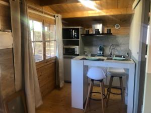 eine Küche mit einer Theke und Hockern in einem Zimmer in der Unterkunft Chalet - Piscine - Wifi in Penta-di-Casinca