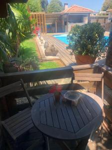 un patio con mesa, banco y piscina en Chalet - Piscine - Wifi, en Penta-di-Casinca