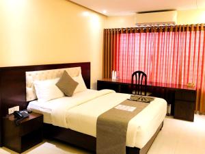 a hotel room with two beds and a lamp at Richmond Hotel Sylhet in Sylhet