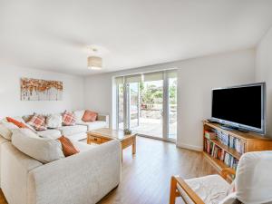 a living room with a couch and a flat screen tv at Coney Garth Barn in Beckermet