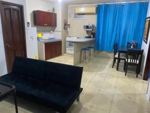 een woonkamer met een bank en een keuken bij Playa Suites, cerca del Malecon in Manta
