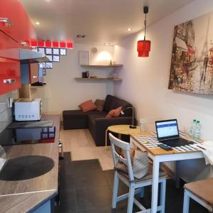 a kitchen and living room with a table with a laptop at Apartament Robotnicza in Sanok