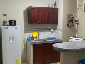 cocina con fregadero y nevera en Playa Suites, cerca del Malecon, en Manta