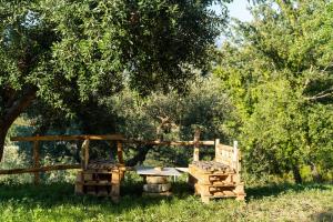 a garden with a table and a fence and trees at U Saccataro Casa Vacanze in Ogliastro Cilento