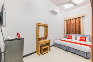 a hotel room with a bed and a mirror at Super OYO 110 Ras Al Hadd Guest House in Al Ḩadd