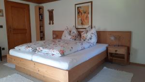 a bed with a wooden frame and pillows on it at Montafonerhaus in Schruns