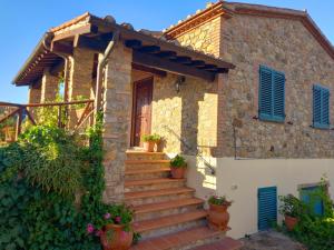 a stone house with stairs in front of it at Agriturismo La Casina in Saturnia