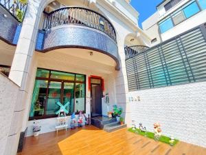 a building with a balcony and a wooden floor at Loyo Royalty in Donggang