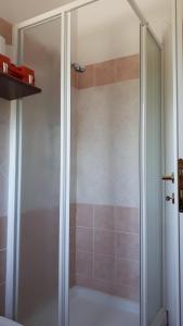 une douche avec une porte vitrée dans une salle de bain dans l'établissement House in San Teodoro among the scents of Sardinia, à San Teodoro