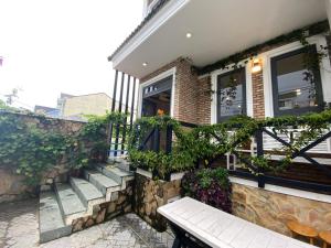 a bench sitting outside of a house with plants at Garden View Villa Đà Lạt - 8 Rooms in Da Lat