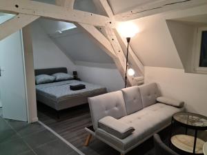 sala de estar con sofá y cama en Beaugency-1 sur la route des Châteaux, en Beaugency