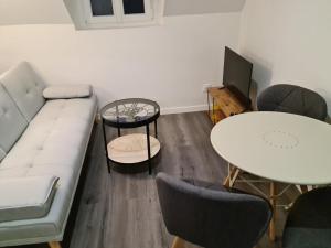 sala de estar con sofá y mesa en Beaugency-1 sur la route des Châteaux, en Beaugency