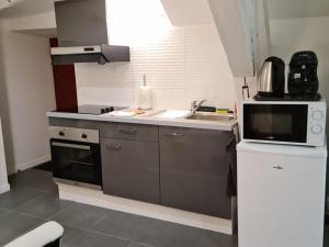 een kleine keuken met een wastafel en een magnetron bij Beaugency-1 sur la route des Châteaux in Beaugency