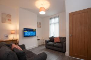 a living room with two couches and a flat screen tv at Cross Street by Prestige Properties SA in Barrow in Furness