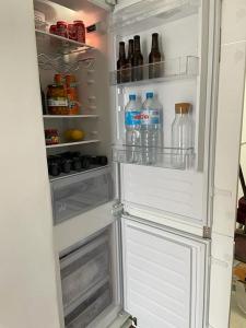 um frigorífico aberto cheio de garrafas de água e bebidas em Villa para disfrutar en el Valle Golf Resort em Múrcia