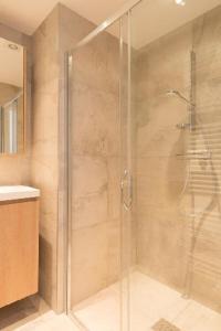 a shower with a glass door in a bathroom at Prachtig Zeezicht Appartement in Ostend