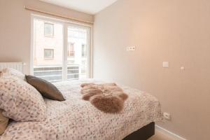 a bedroom with a bed with a stuffed animal on it at Prachtig Zeezicht Appartement in Ostend