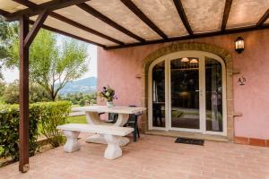 a patio with a table and a bench at Residence Borgo Felciaione in Riparbella