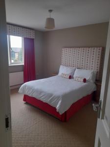 um quarto com uma cama grande e uma cabeceira vermelha em 112 Roseberry Hill em Newbridge