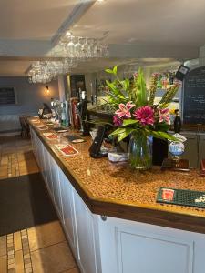 a bar with a vase of flowers on a counter at The Railway Inn in Rise