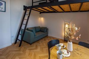 ein Wohnzimmer mit einem Hochbett, einem Tisch und einem Sofa in der Unterkunft Hillside7 Micro-Loft in Bielsko-Biała